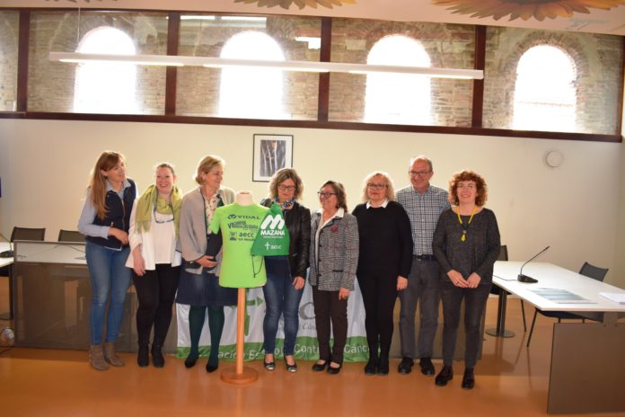 Autoridades y voluntarios de la AECC posan con la camiseta conmemorativa de la Carrera-Marcha de 2019 (Foto: Angel Gayúbar)
