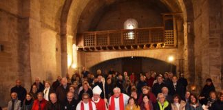 El obispo, los pueblenses y sus amigos en un a imagen de grupo en el interior d ela iglesia de San Román (Foto: Angel Gayúbar)